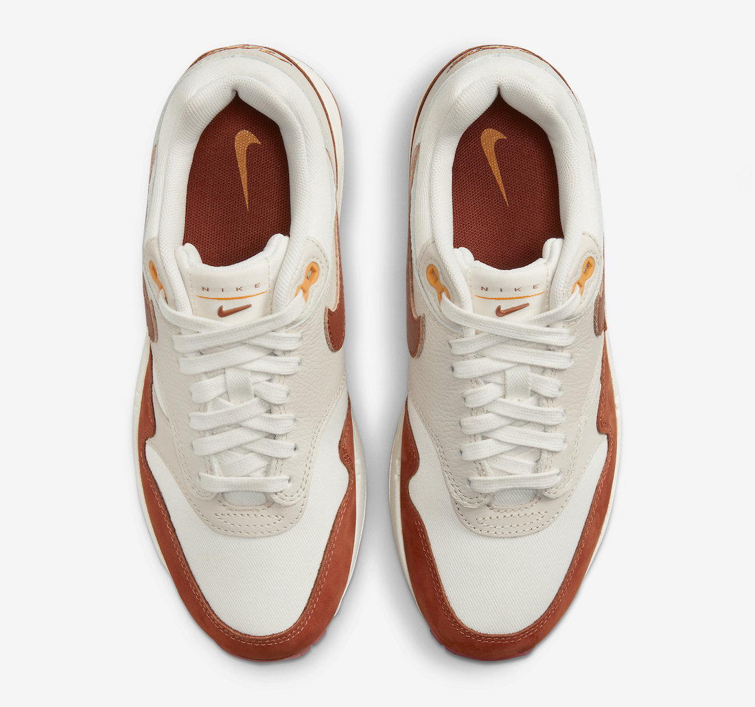 Dressed in a Sail, Rugged Orange, Light Orewood Brown, and Sundial color  scheme. This offering of the Nike Air Max 1 comes constructed in