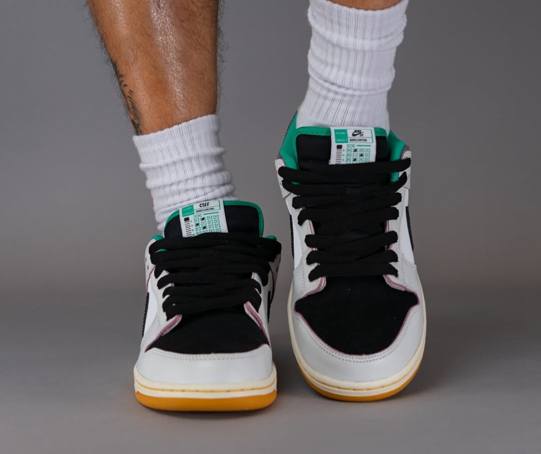 A direct front look at the CSEF x Nike SB Dunk Low, showcasing the black suede toe box, padded tongue, and green lining.