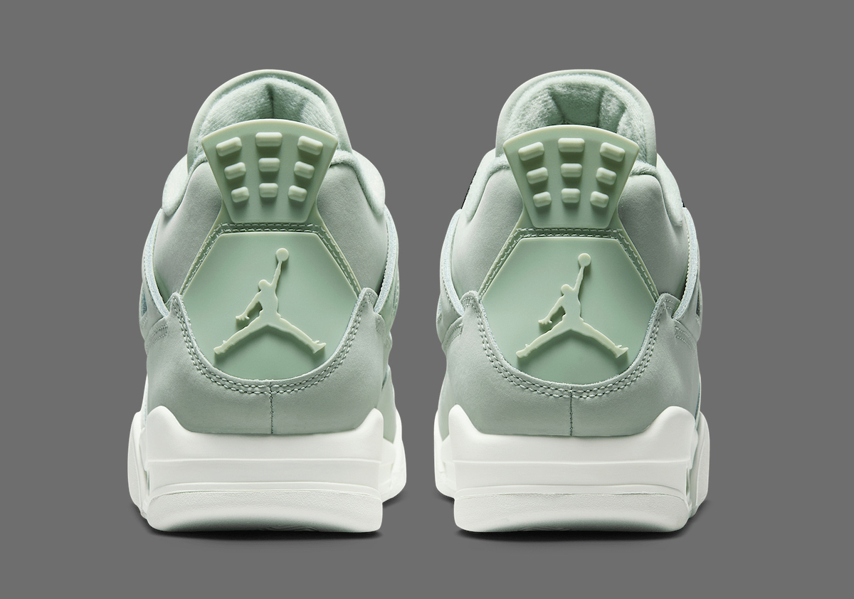 Back view of the Air Jordan 4 'Seafoam' highlighting the molded pastel green heel tabs with embossed Jumpman logos and the white midsole below, against a neutral grey background.