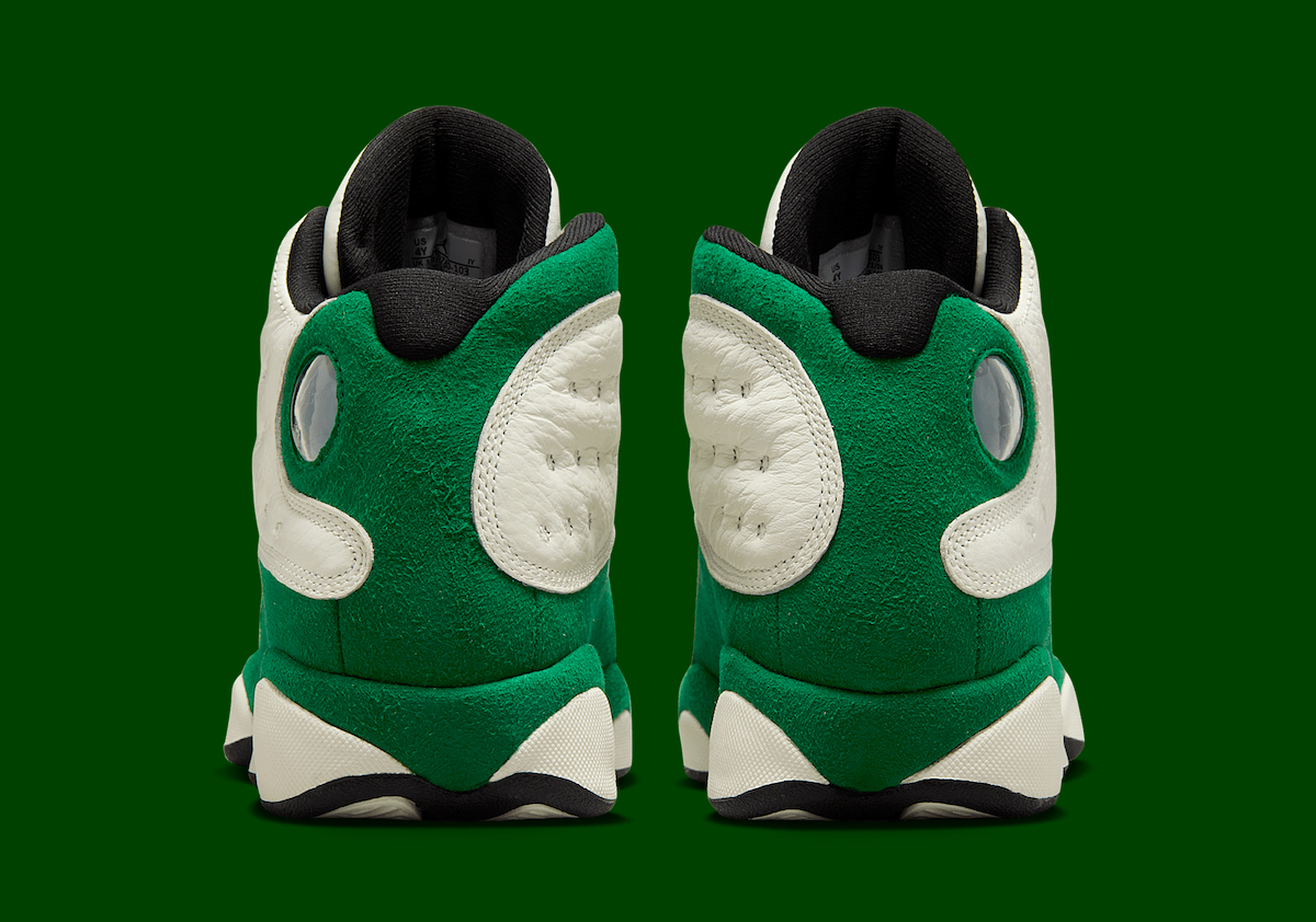 Rear view of the Air Jordan 13 GS Pine Green with the iconic holographic emblem and green suede heel.