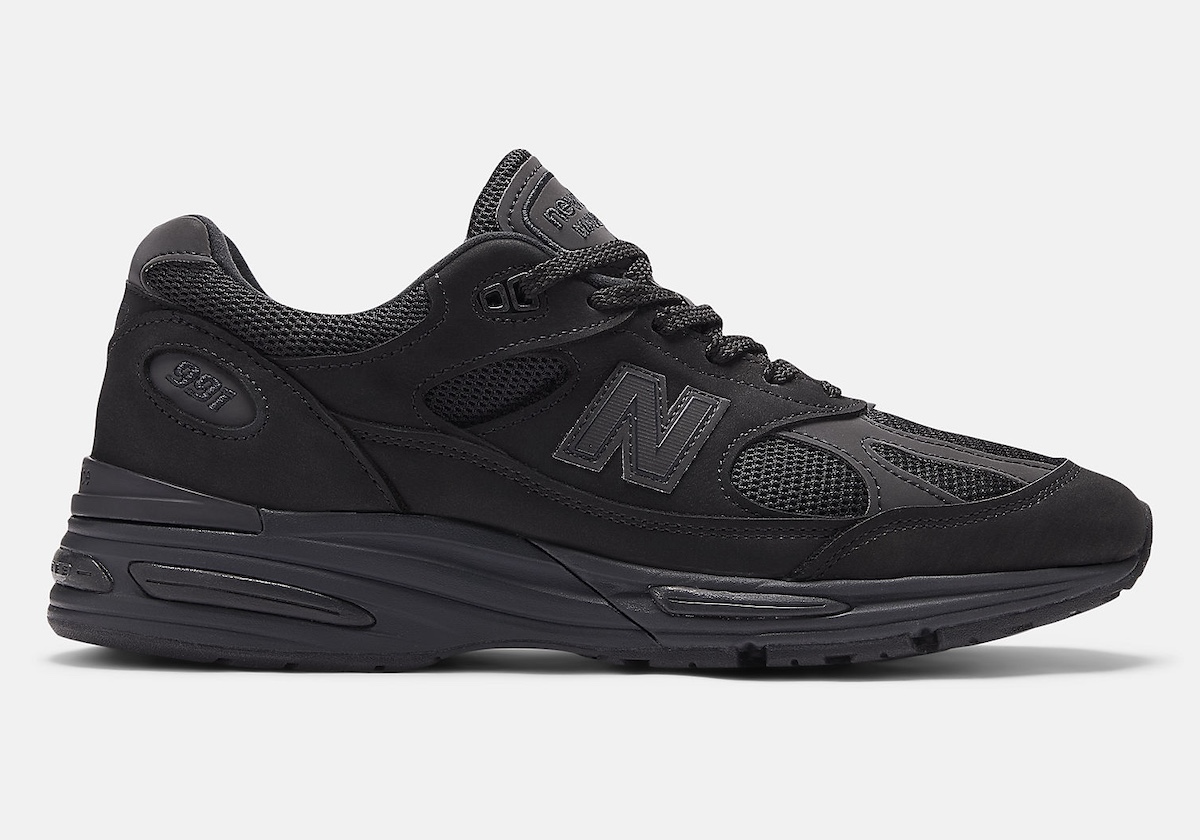 Side view of Dover Street Market x New Balance 991v2 Triple Black showcasing nubuck overlays and mesh panels