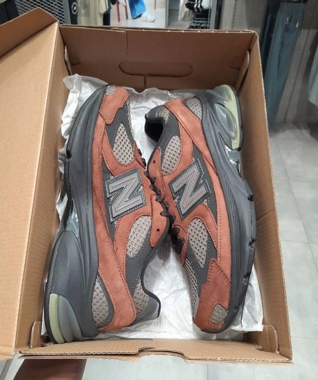 Top-down view of the New Balance 2010 Brown neatly placed inside its box