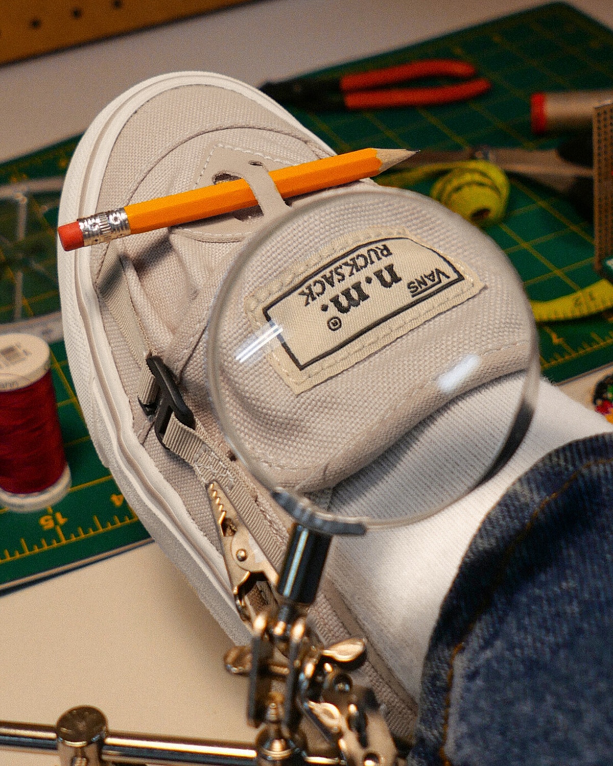 In-studio close-up of the cream Vans Slip-On RS under a magnifying glass, highlighting design details.