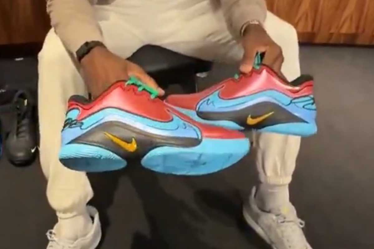 LeBron James holding the Nike LeBron 22 Captain Planet PE, showcasing the colorful design inspired by the classic animated series.