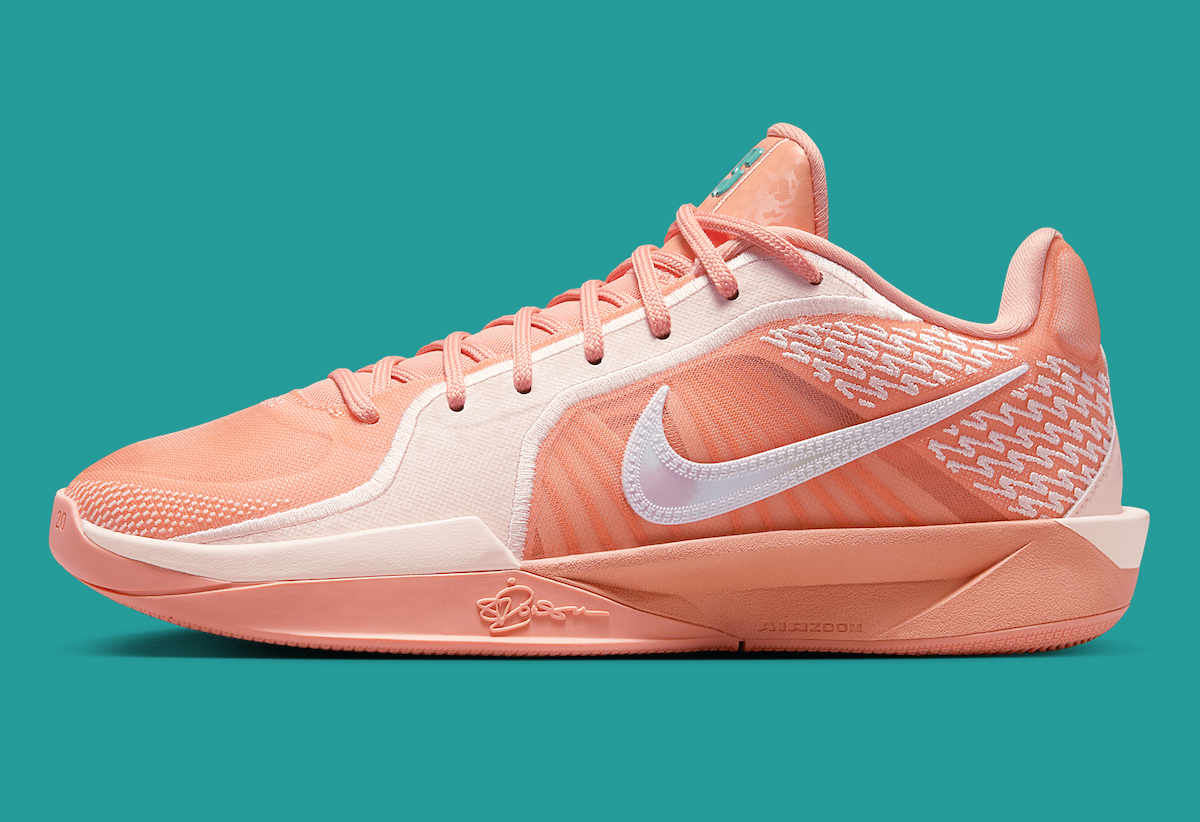 A side view of the Nike Sabrina 2 Apricot Agate/Washed Coral, showcasing the white Nike Swoosh, embroidered pattern, and peach-colored foam midsole.