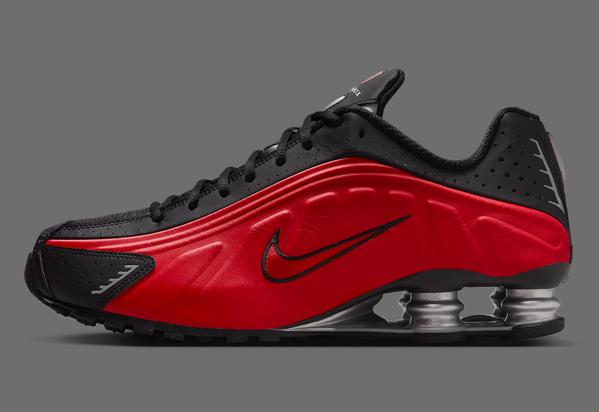 Side profile of the Nike Shox R4 Black/Red, highlighting the embroidered black Swoosh and molded synthetic upper.