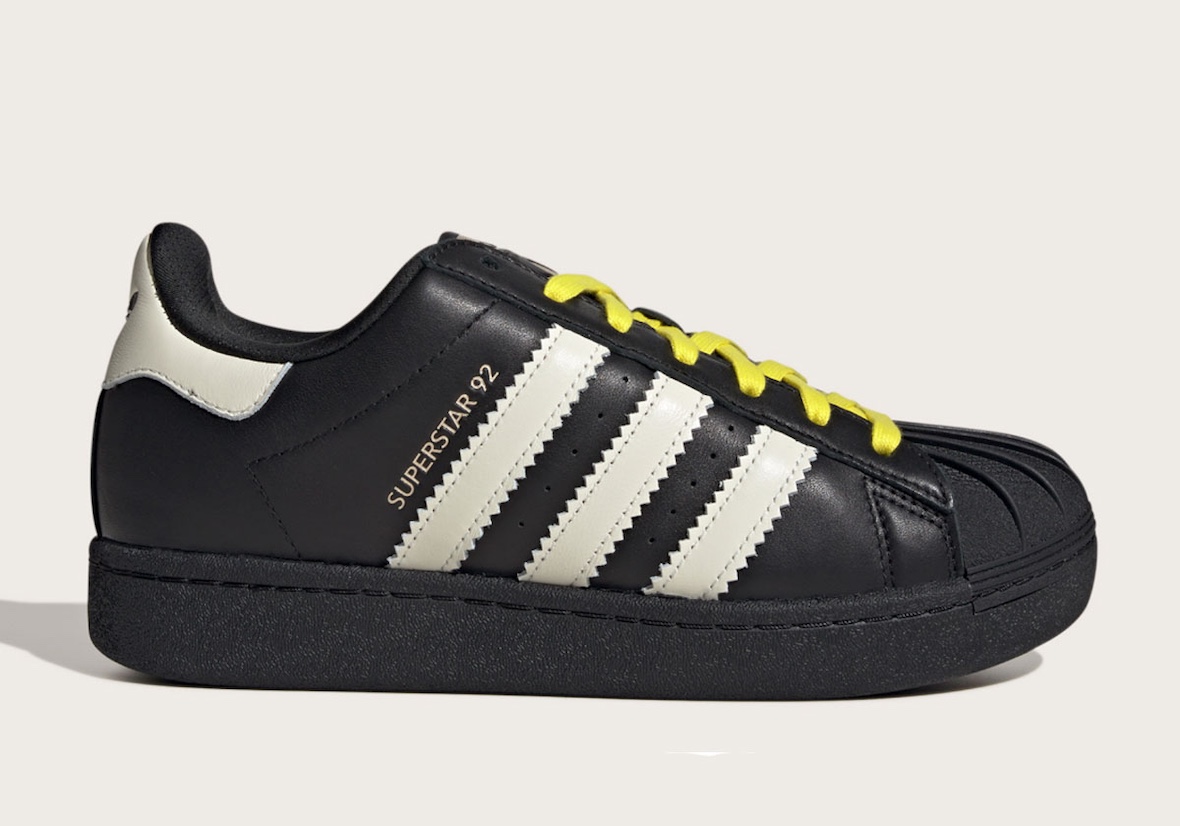 Pharrell x adidas Superstar 92 in black with cream stripes and yellow laces.