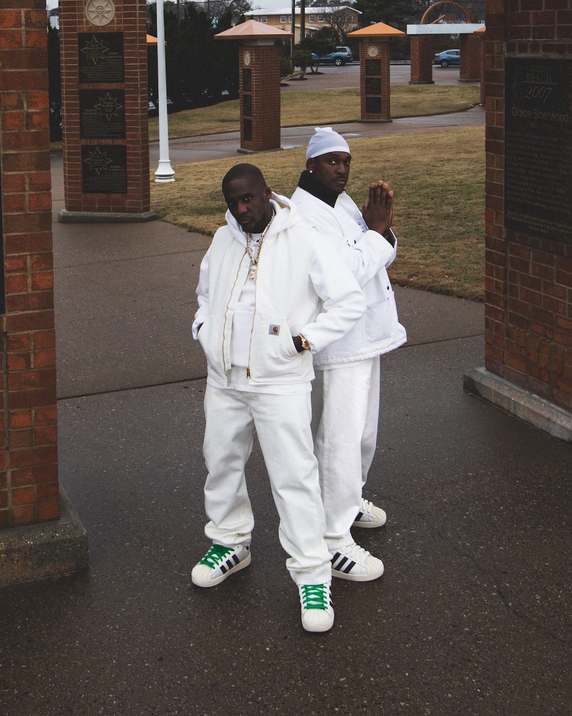 Clipse in all-white outfits showcasing the Superstar 92 with green laces.