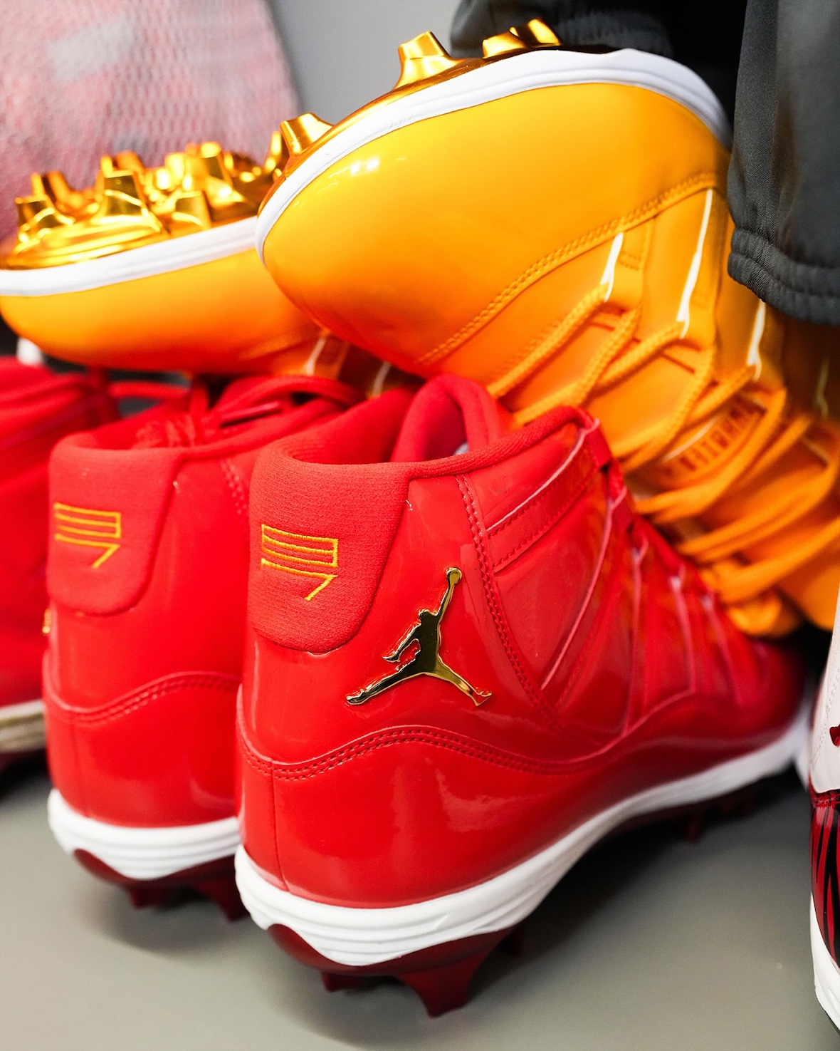 Close-up of Travis Kelce's all-red Air Jordan 11 cleats featuring jersey number 87 stitched on the heel