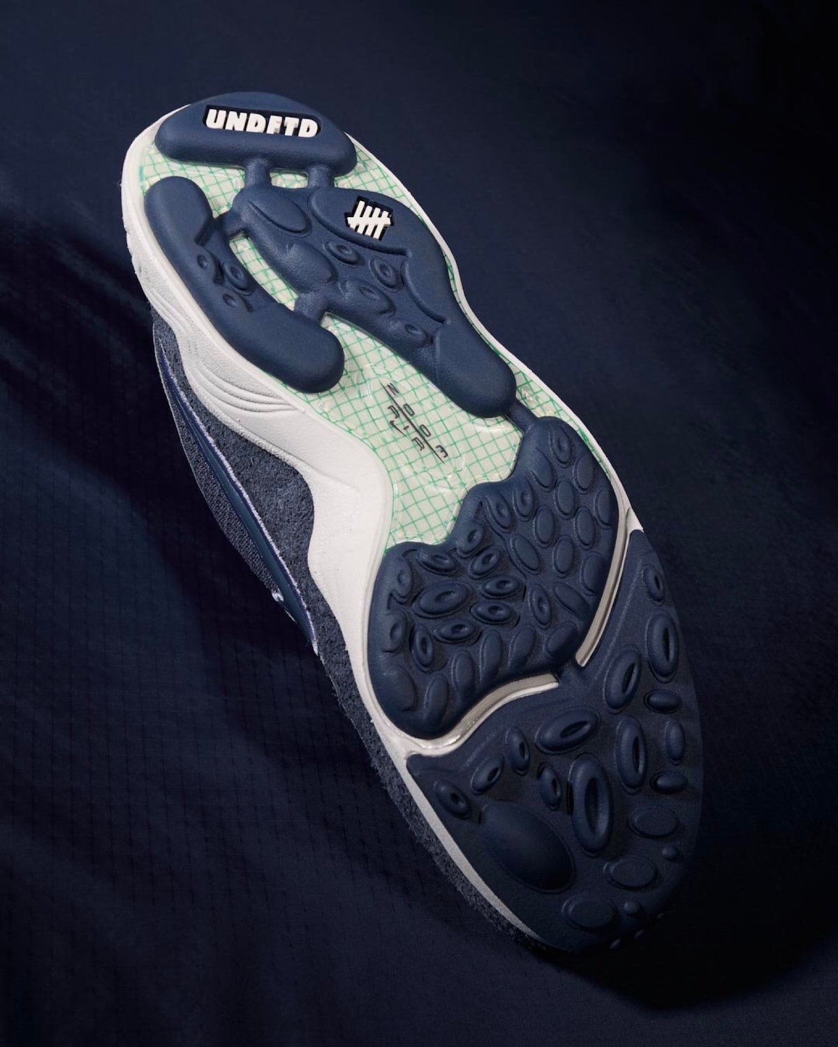 Outsole view of Undefeated x Nike Air Zoom Spiridon with co-branded logos