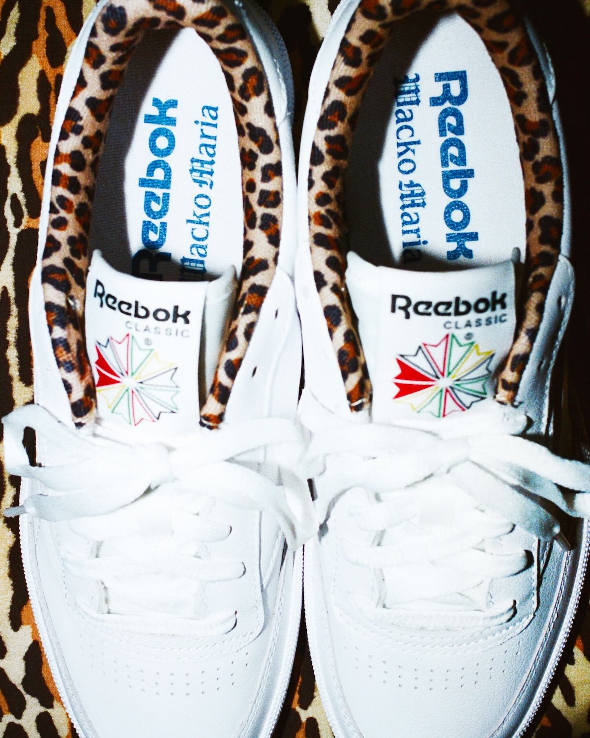 Close-up of WACKO MARIA x Reebok Club C 85 White on leopard-print surface