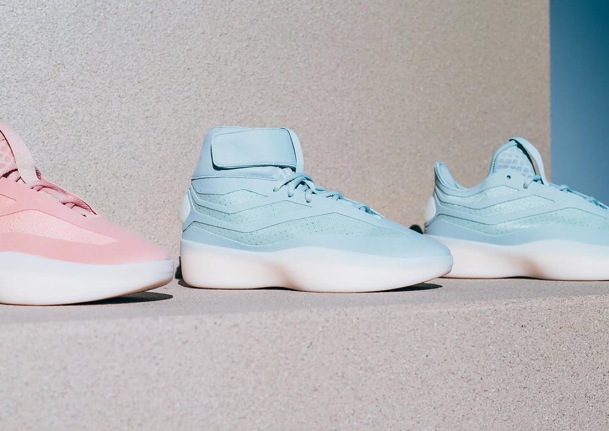 Side profile of the adidas Fear of God Athletics Basketball II in Ash Silver and Ash Pearl lined up outdoors.
