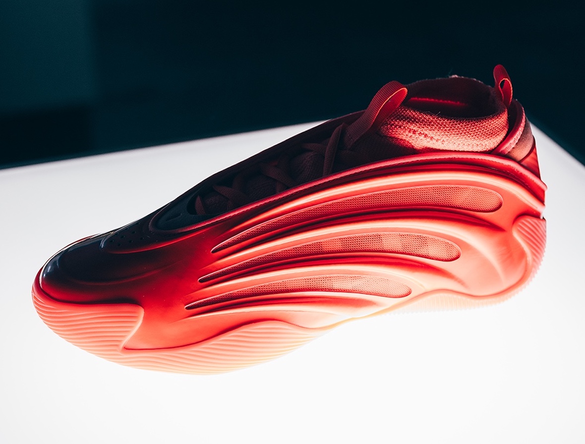 The adidas Harden Vol 9 Dynamo in bright orange, displayed under spotlight.