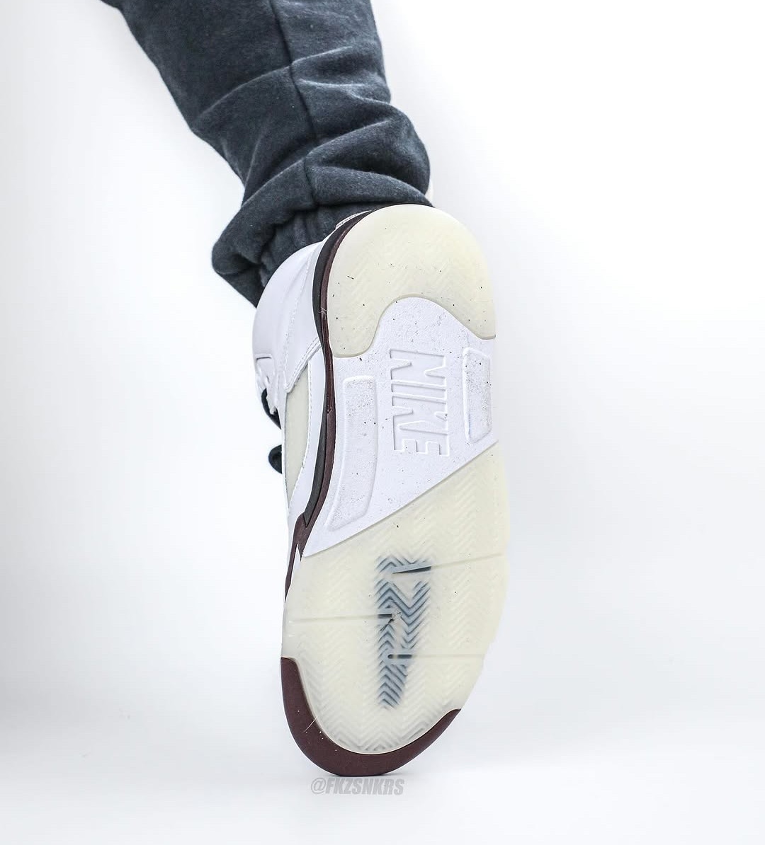 A bottom view of the A Ma Maniére x Air Jordan 5 highlighting the icy translucent outsole with 'Nike' branding and visible traction details.