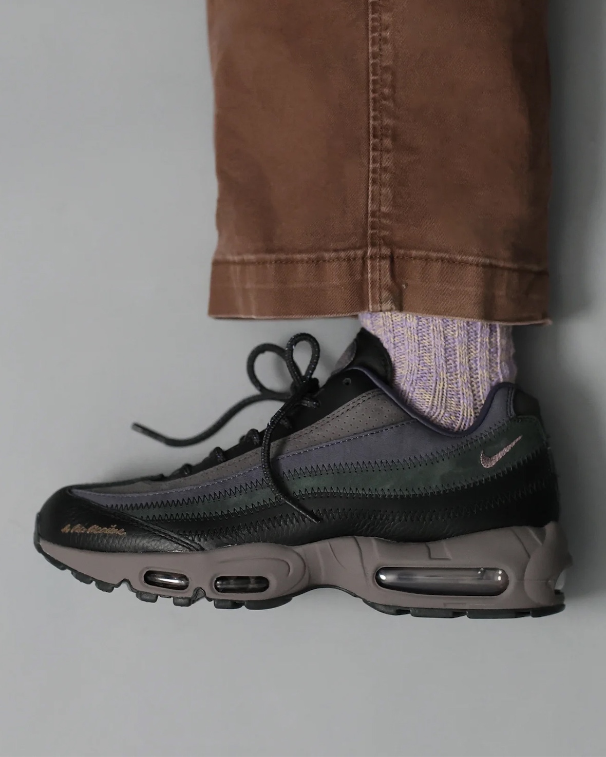 A stylish on-foot shot of the A Ma Maniére x Nike Air Max 95 collaboration in Diffused Taupe, showcasing the sneaker’s earthy tones and luxury craftsmanship.