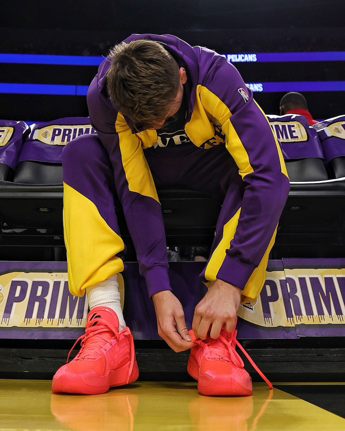Luka Doncic lacing up the Jordan Luka 4 Flash Crimson courtside.