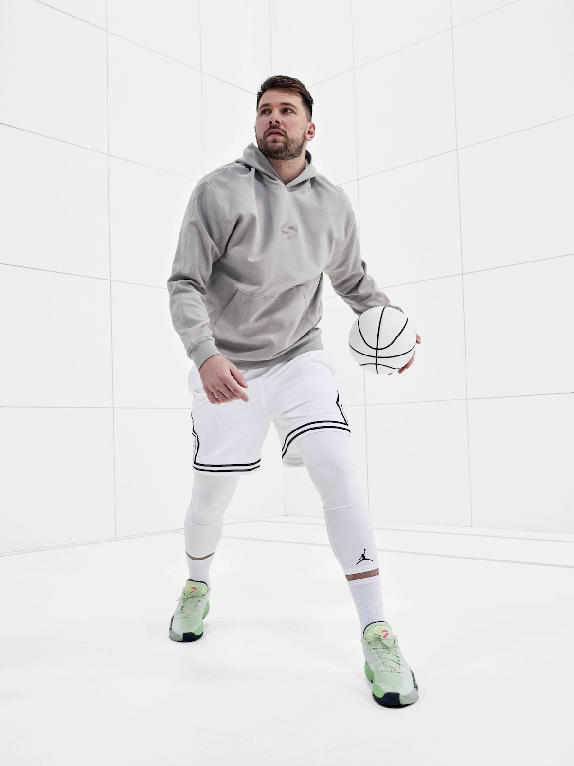 Jordan Luka 4 "Space Navigator" on Luka Dončić wearing a grey hoodie and white shorts.