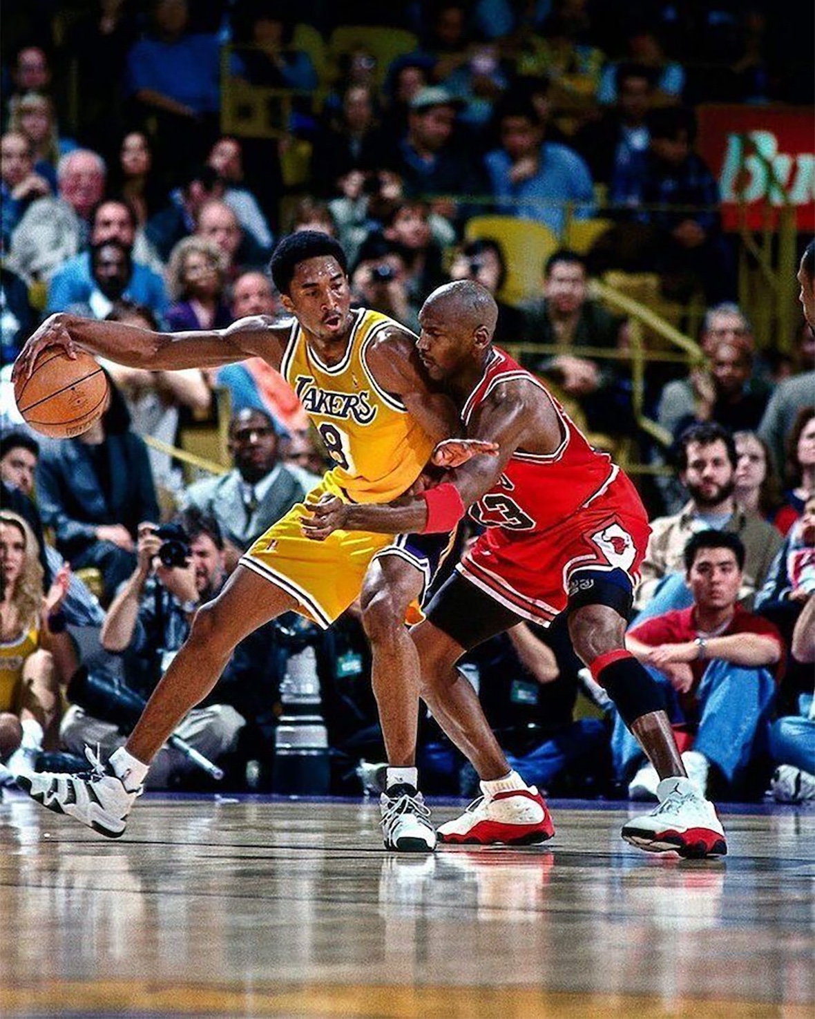 Michael Jordan guarding Kobe Bryant while wearing the Air Jordan 13 OG True Red Chicago colorway from 1998.