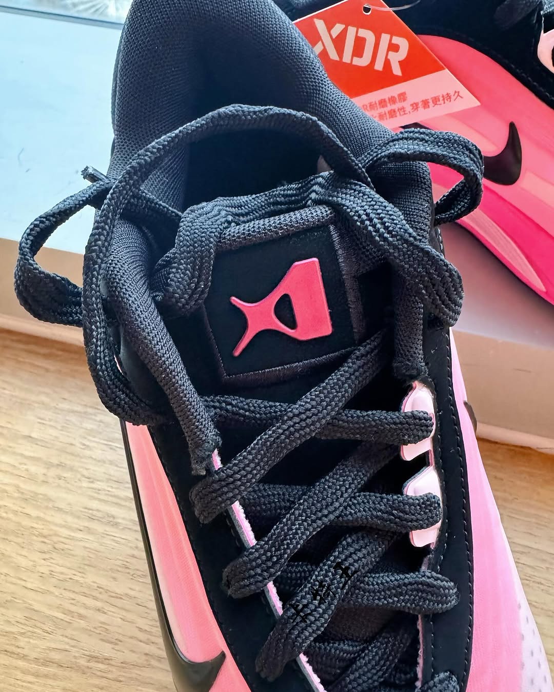 Close-up of the Nike A'One 'Black/Pink' tongue featuring A'ja Wilson's personal logo in pink, thick black laces, and high-performance materials for enhanced durability.