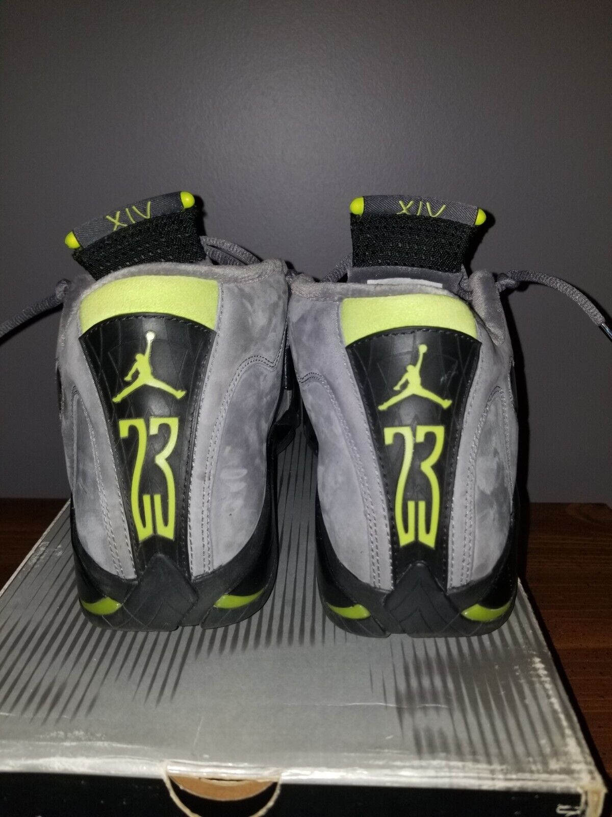 Rear view of Air Jordan 14 Retro Chartreuse from 2005 – Features bold 23 branding, chartreuse Jumpman logo, and carbon fiber heel panel. Retro pair positioned on original box.