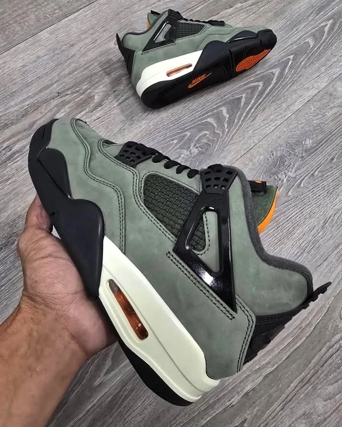 Side view of the Undefeated Air Jordan 4 OG 2025 with Nike Air branding and orange Air unit