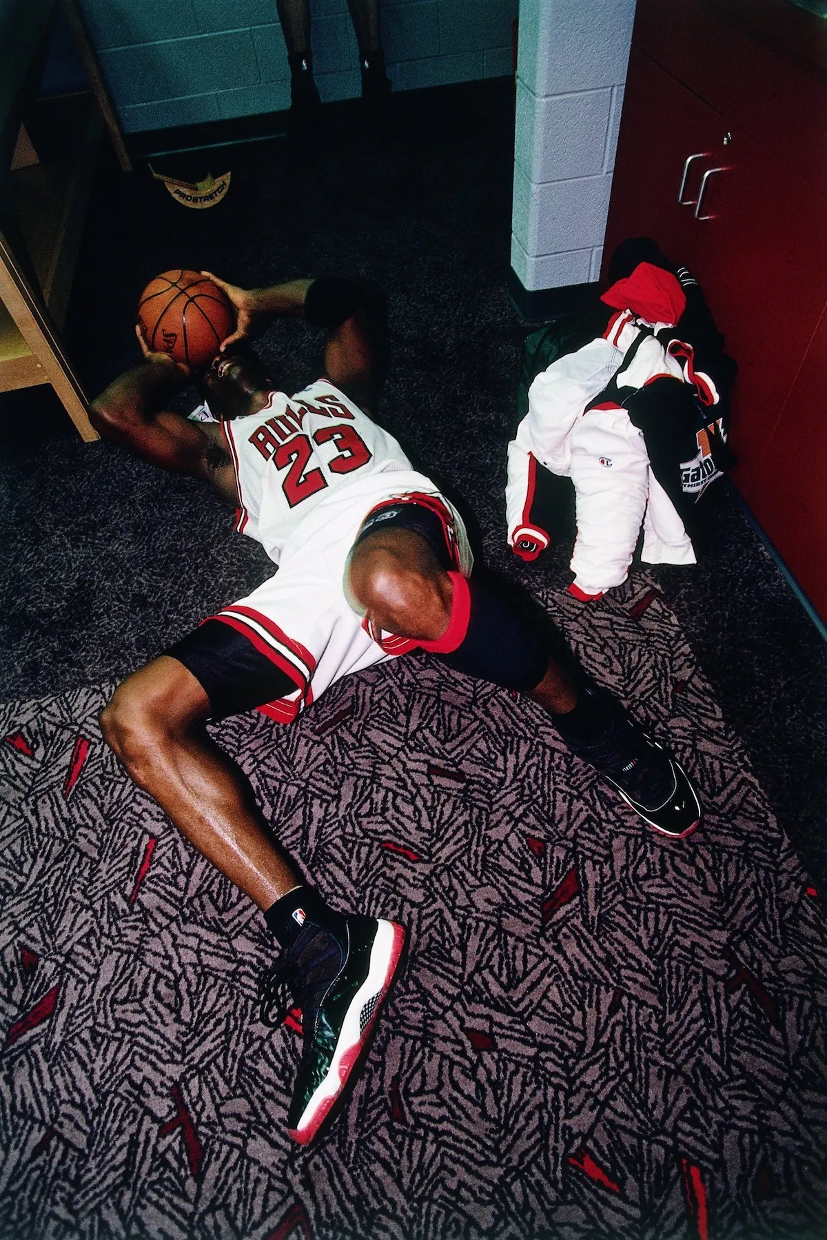 Michael Jordan lying on locker room floor hugging basketball after 1996 NBA Finals win on Father’s Day