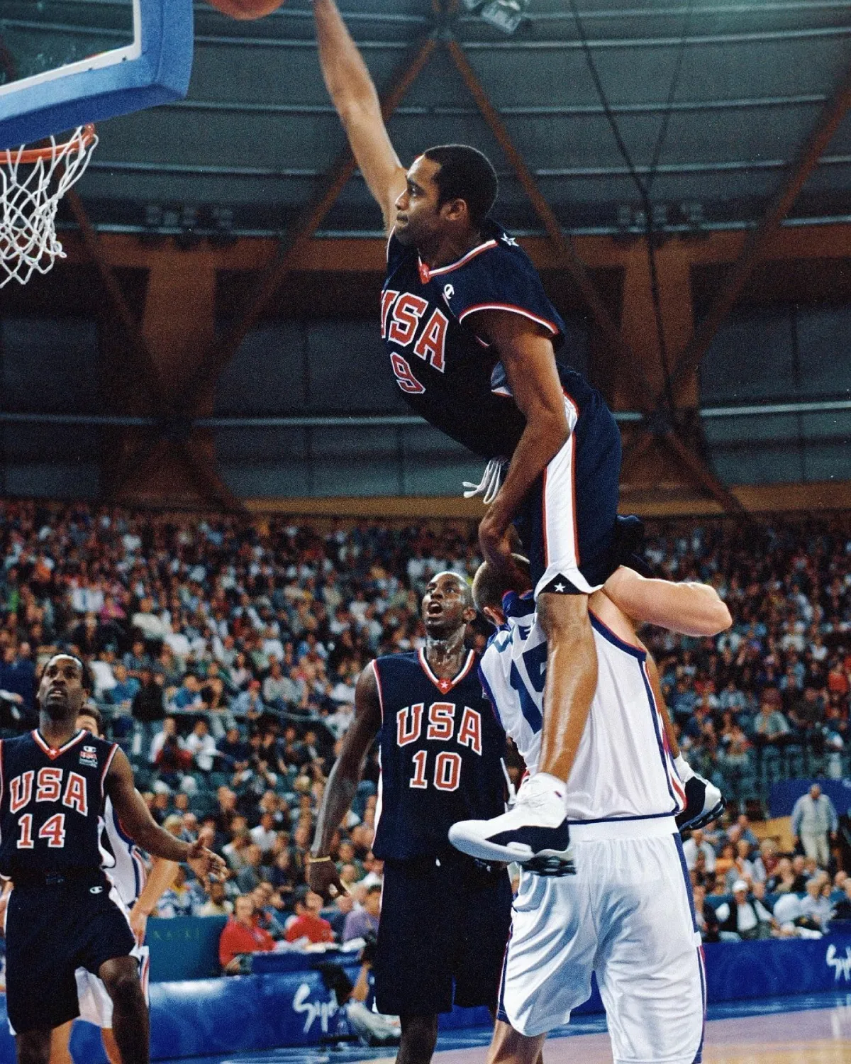Vince Carter dunks over France’s Frederic Weis during the 2000 Sydney Olympics while wearing Team USA jersey.