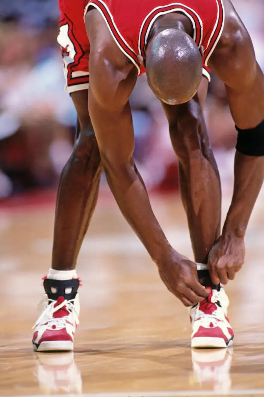 Michael Jordan lacing up the Air Jordan 6 Carmine on court