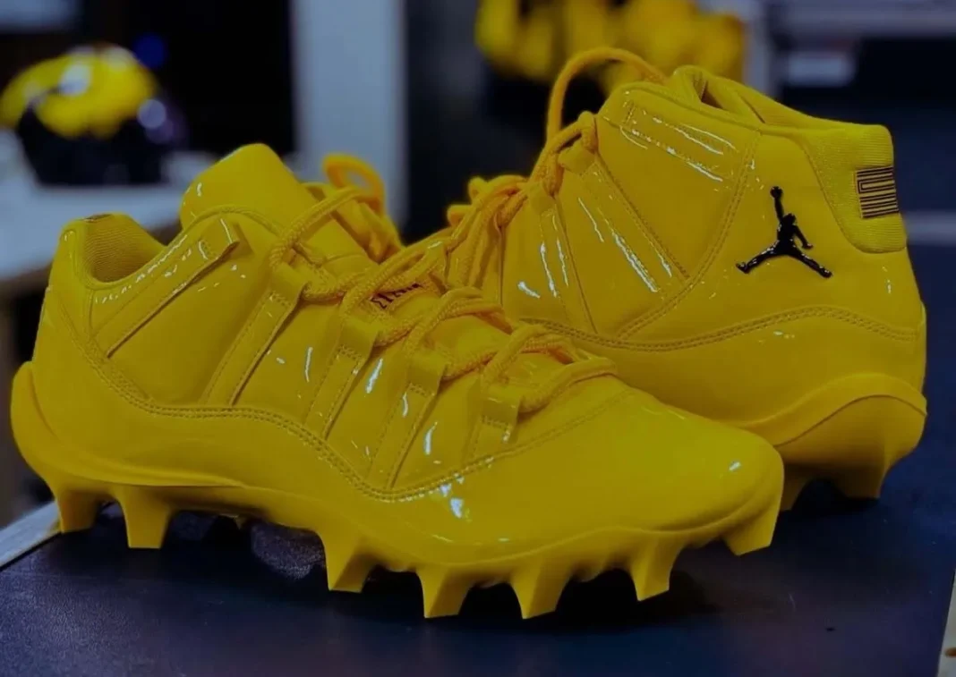 Michigan Air Jordan 11 cleat in maize yellow with black heel and ankle detailing, player-exclusive PE for Wolverines football - detail view 1