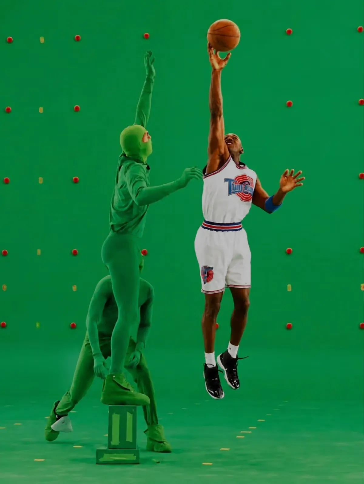 Michael Jordan filming the Space Jam basketball scene on a green screen with performers in green suits.